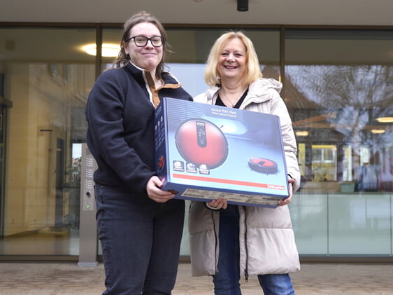 Verwaltungspraktikantin Evelyn Kärcher überreicht den Hauptgewinn des Nordheimer Adventskalenders – einen Saugroboter – gestiftet von der Firma Eberhard an die glückliche Gewinnerin Edith Buchwald.