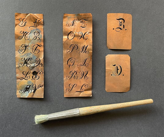 Schablonen zum Aufmalen von Buchstaben mit wasserlöslicher Farbe auf die Wäsche