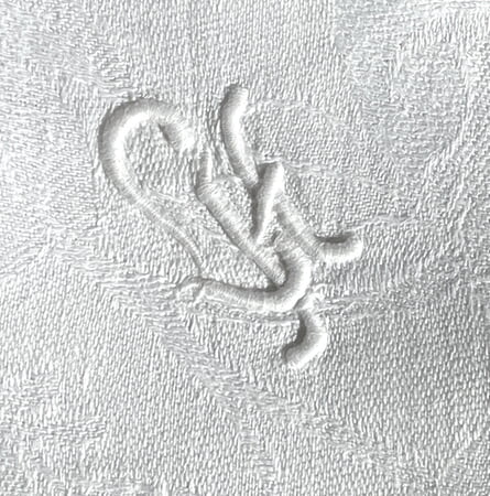 Monogramm „LH“ (L H) auf einer edlen Tischdecke