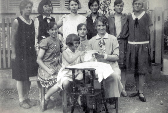 Mädchen mit Lehrerin beim Sticken an einem Stickrahmen