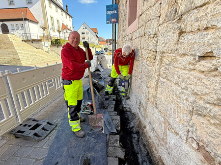 Christian Hess und Andreas Hahn vom Bauhof legen den Sockel der B&uuml;cherei frei