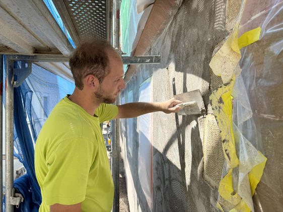 Gekonnte handwerkliche Arbeit wird an der Fassadensanierung der Ortsb&uuml;cherei demonstriert; hier von Niko Kicherer.