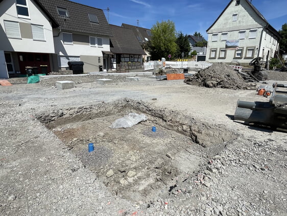 Ausgehobenes Baumquartier auf dem Kelterplatz mit den Fundamenten der Pergola im Hintergrund.