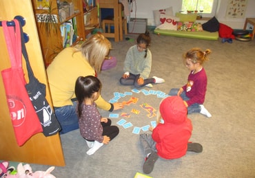Kinder mit Erzieherin beim Spielen