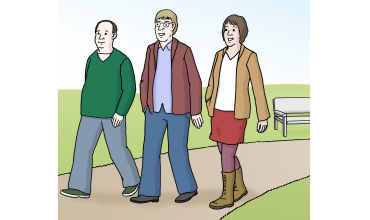 Drei Personen gehen nebeneinander auf einem Weg. Von links: Mann, Mann mit Jacke, Frau.